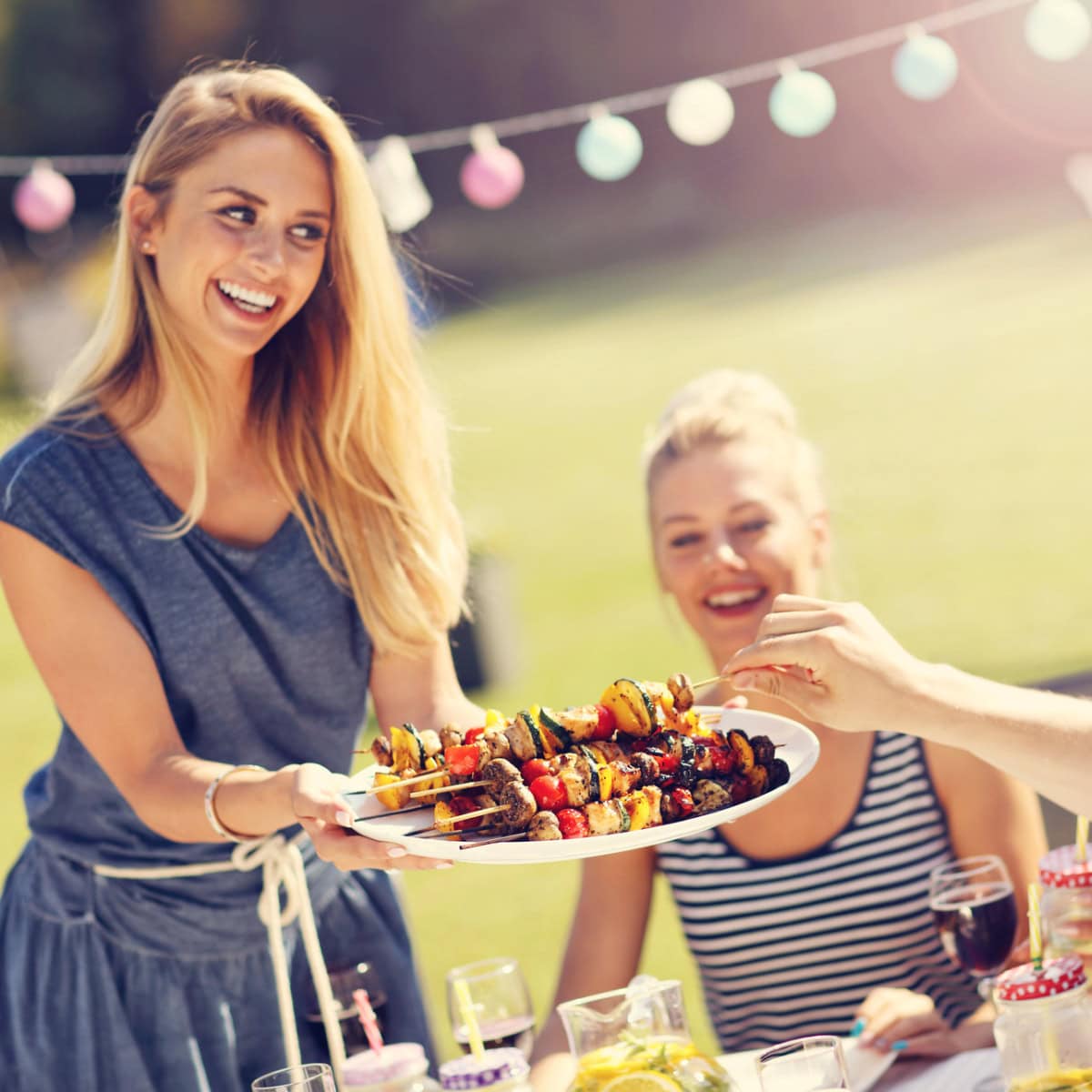 serving trays feature image - woman serving kabobs on a white plate